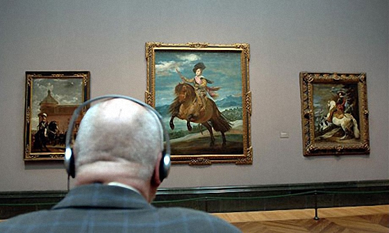 Gallery patron listening to headphones while viewing art