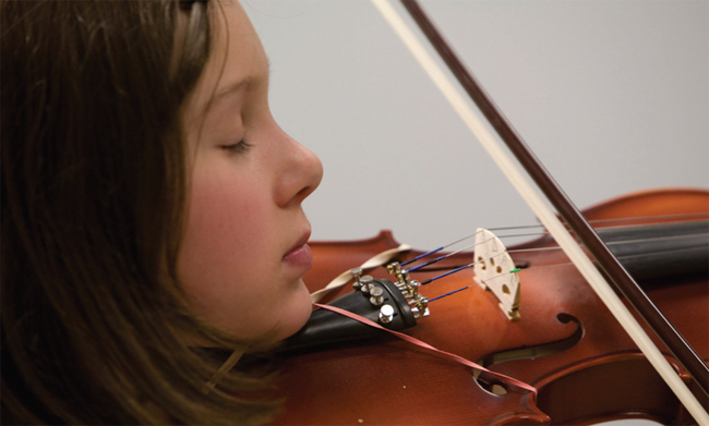 Girl playing violin with eyes closed