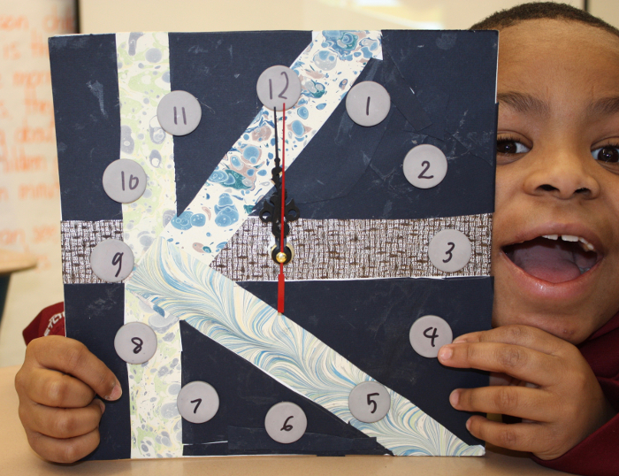 Student holding his clock artwork